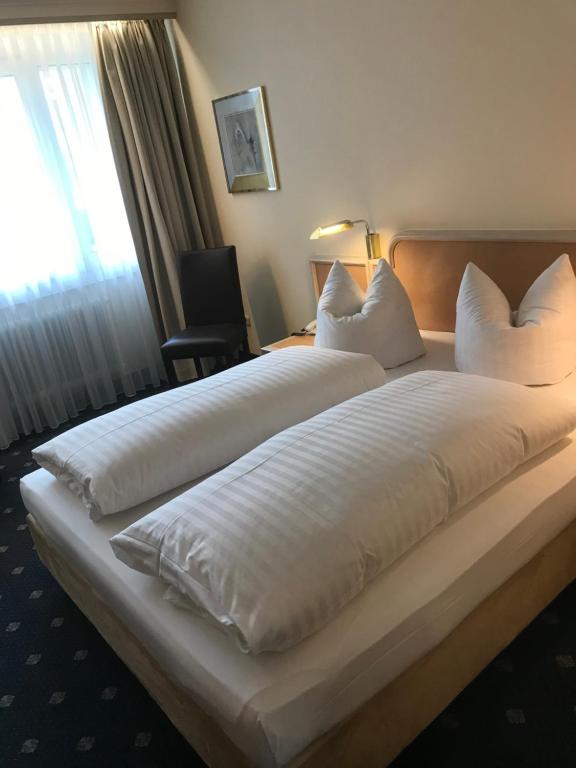 慕尼黑安比恩特甘尼酒店的一张大白色床,位于酒店带窗户的房间内