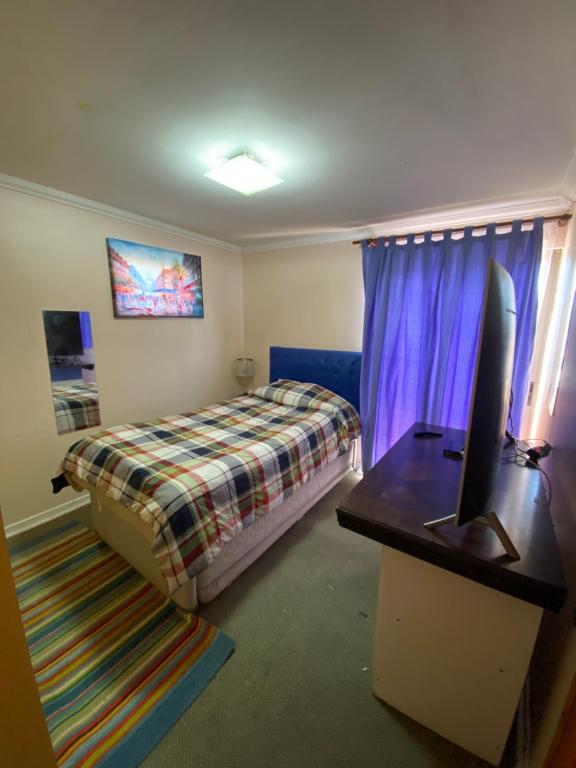 卡拉马Habitaciones con baño compartido的一间卧室配有一张床和一张书桌及电视