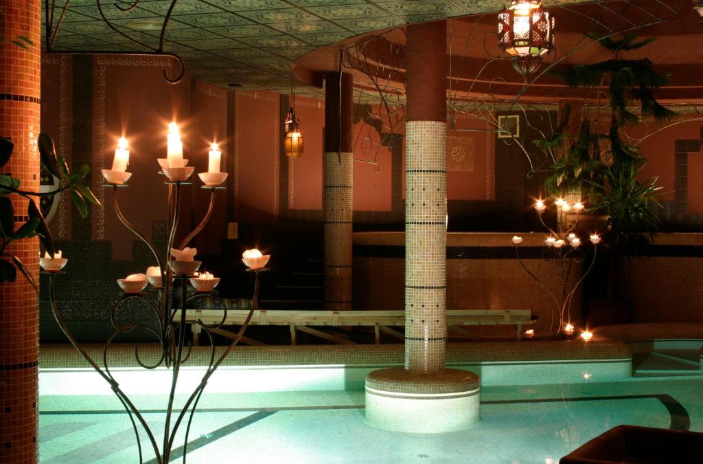 比考尔Puchner Kastélyszálló的客房设有带蜡烛和柱子的游泳池。