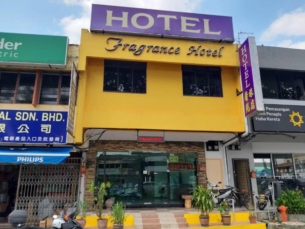 士姑来Fragrance Hotel Johor Bahru的一条在前面有植物的街道上的酒店