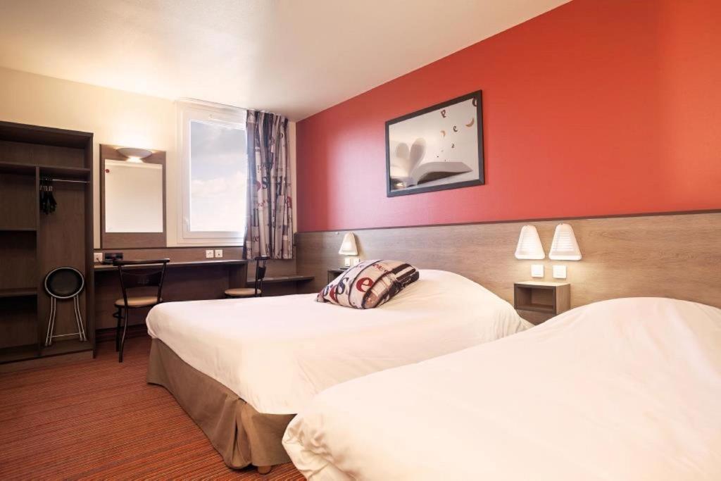 普瓦捷艾斯普瓦捷酒店的酒店客房,设有两张带红色墙壁的床