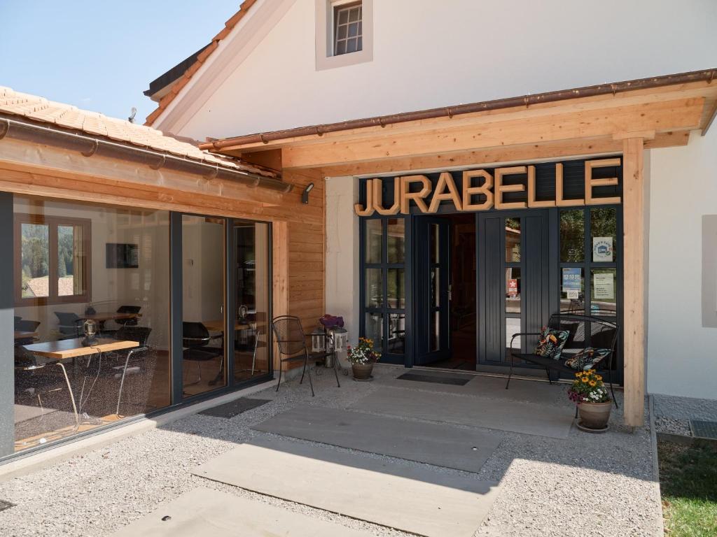 La Côte-aux-Fées朱拉贝尔住宿加早餐旅馆的带有读取ugate的标志的商店前部