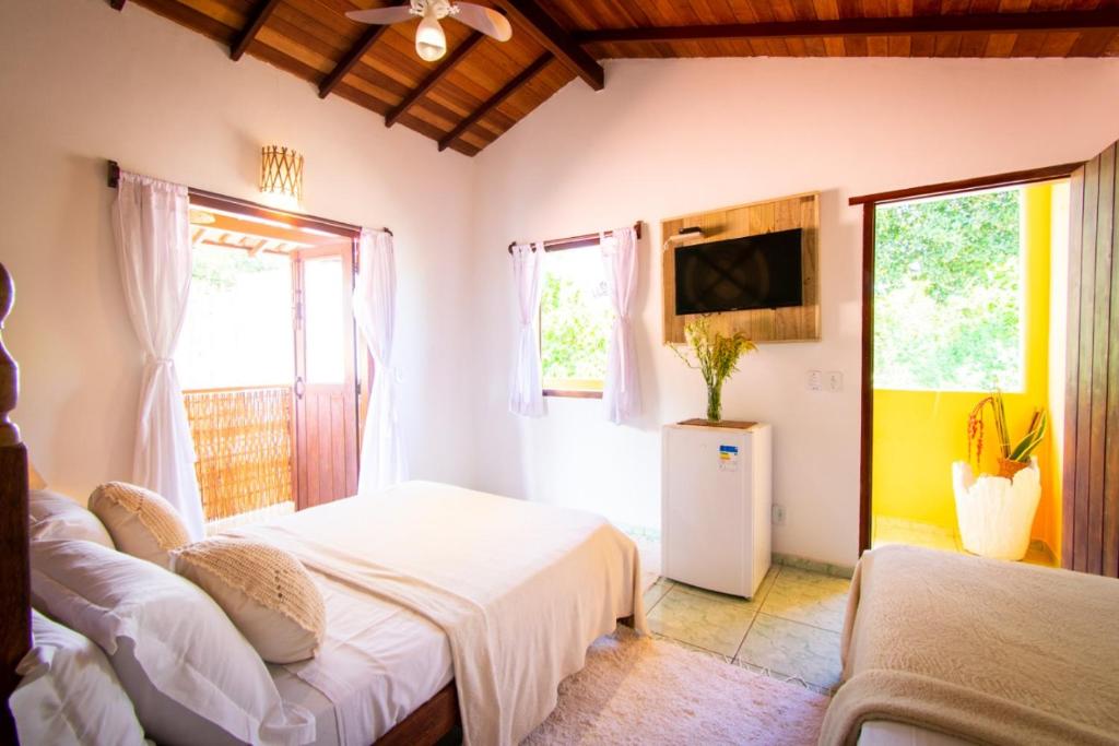 托兰克索Pousada Por do Sol的一间卧室设有两张床、一台电视和窗户。
