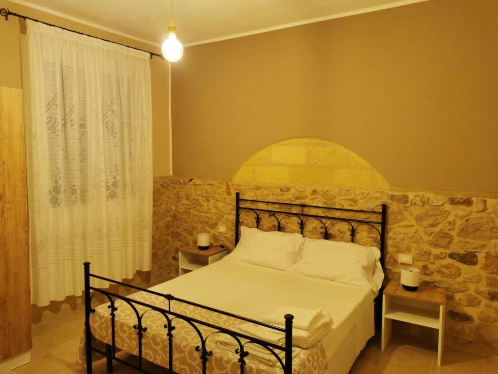 库斯托纳奇Cuore di Conchiglia的一间卧室配有一张石墙床