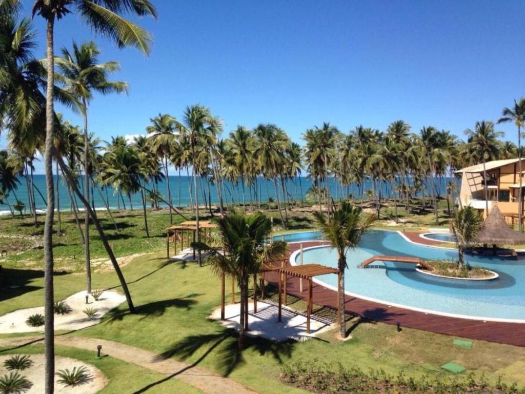 普拉亚多Apt Coral Azul Iberostate Praia do Forte的享有度假村的空中景致,设有游泳池和棕榈树