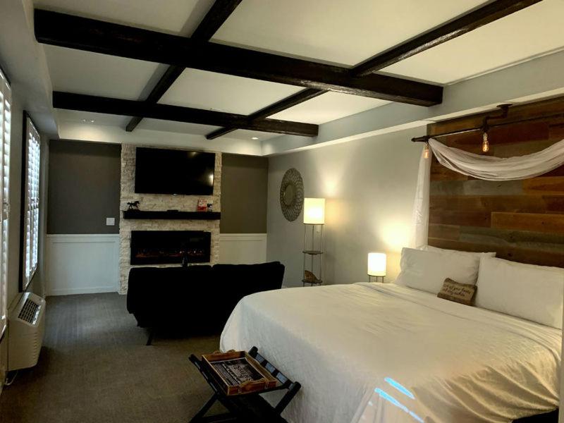 桑达斯基Cedar Stables Inn & Suites的卧室配有白色的床和壁炉