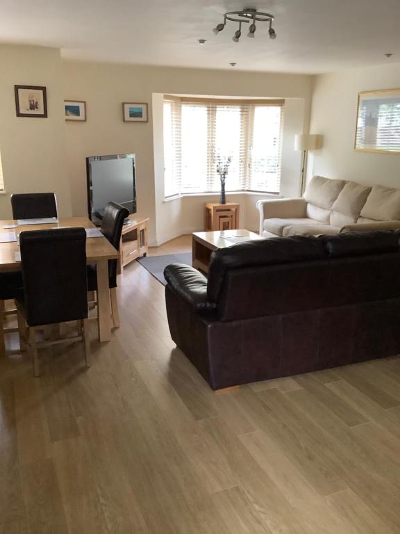 拉格比Simpson's Apartments Rugby Ltd的客厅配有沙发和桌子