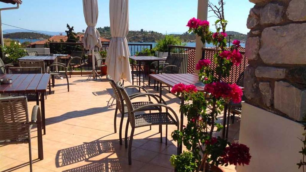 奥马斯帕纳吉亚斯Kallisti的庭院配有桌椅和粉红色的鲜花