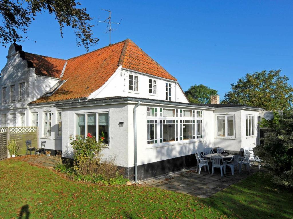 诺德堡10 person holiday home in Nordborg的院子里的白色房子,配有桌椅