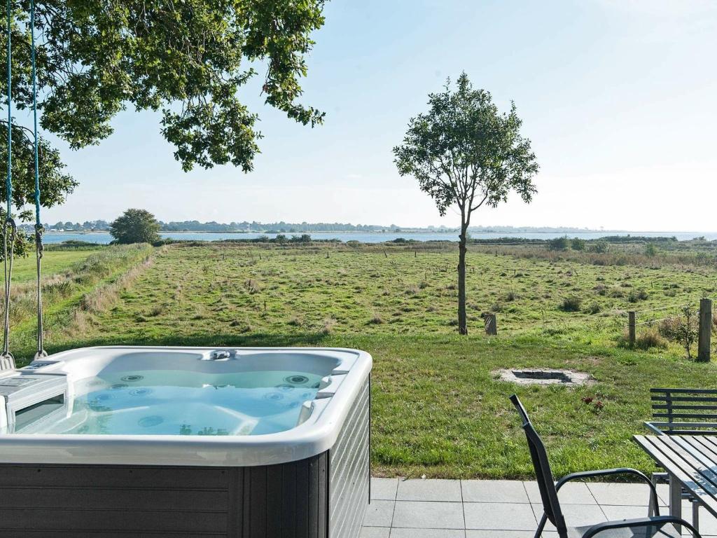 ÅrøsundHoliday home Haderslev II的庭院内的热水浴池,享有田野美景