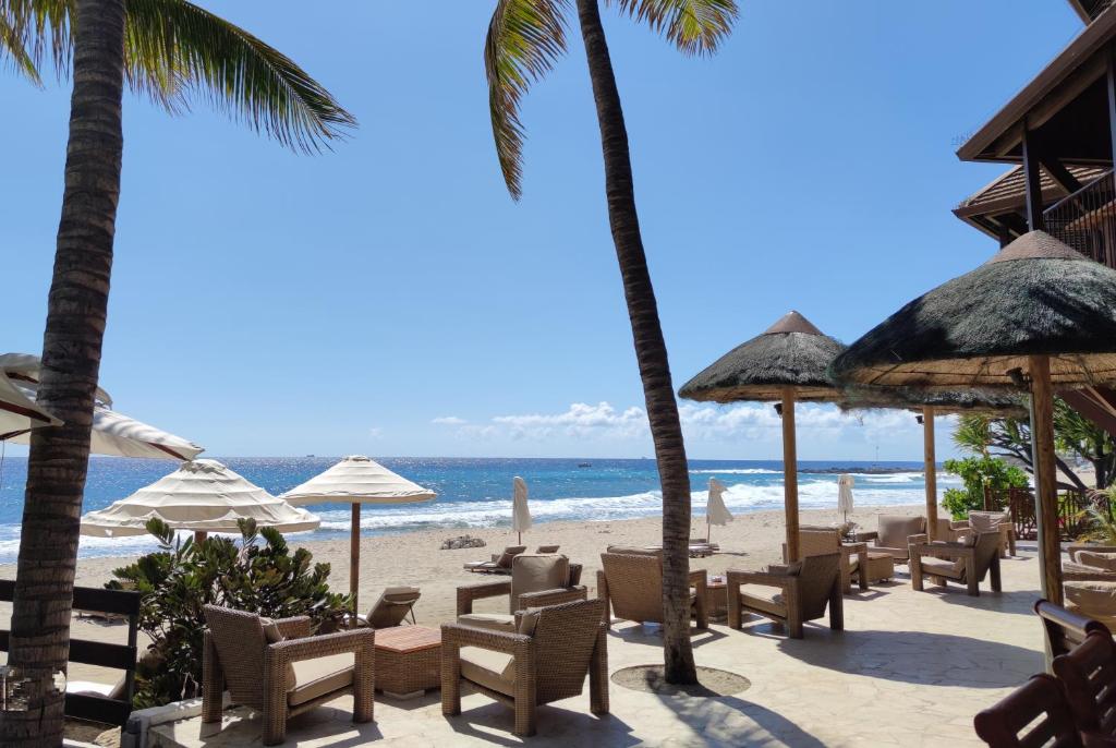 圣吉尔莱班圣亚历克西斯SPA四星酒店的海滩上设有椅子和遮阳伞,还有大海