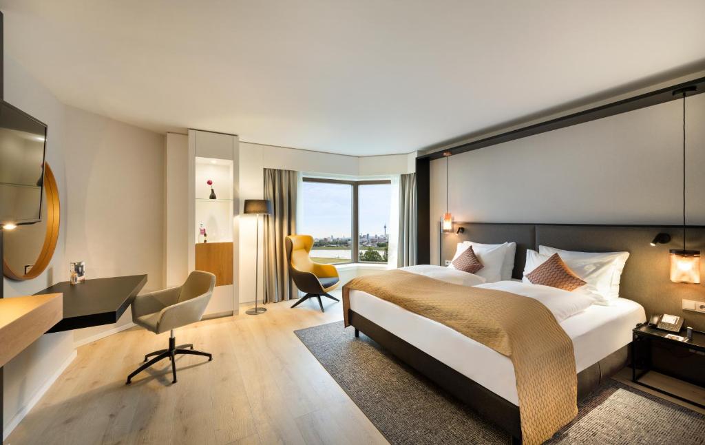 诺伊斯Crowne Plaza Düsseldorf - Neuss, ein IHG Hotel的酒店客房设有一张大床和一张书桌。