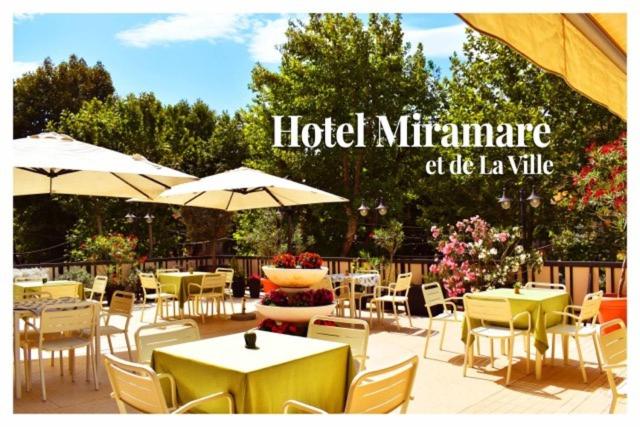 里米尼米拉马雷市酒店的一间带桌椅和遮阳伞的餐厅
