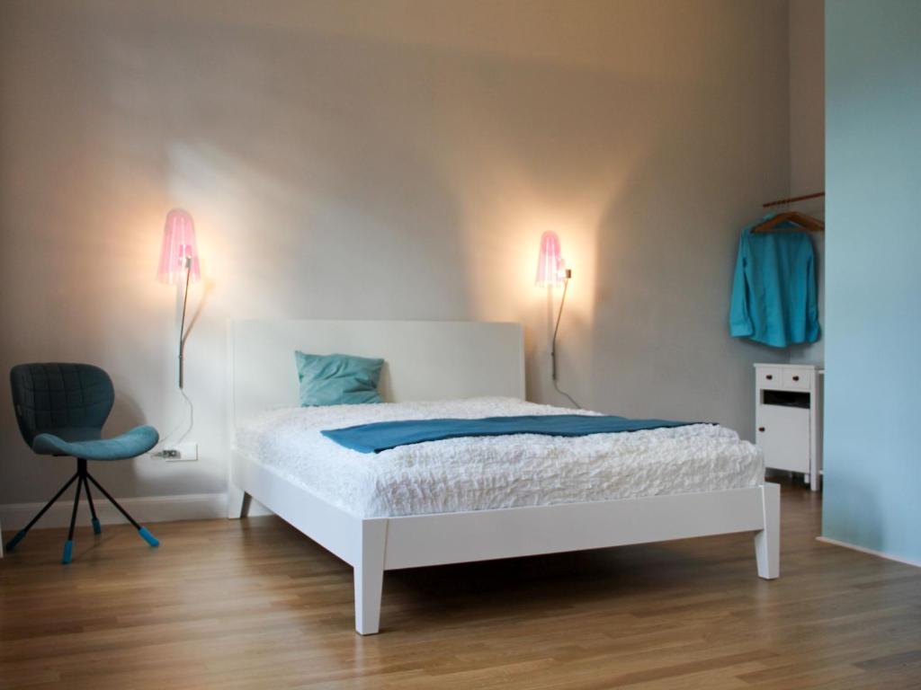 科隆aTa & oMo的卧室配有床、椅子和灯