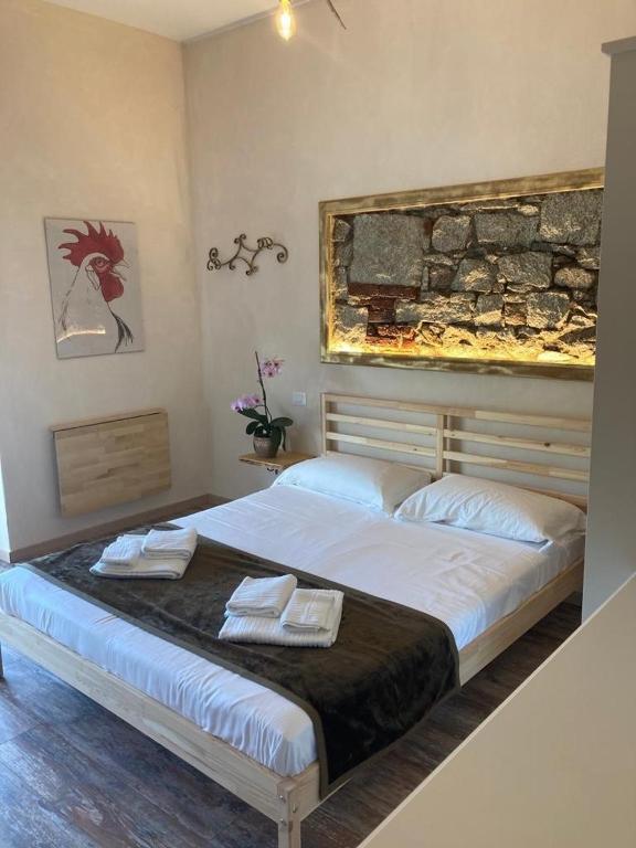 巴韦诺Locanda Il Gallo的一间卧室配有一张大床和两条毛巾