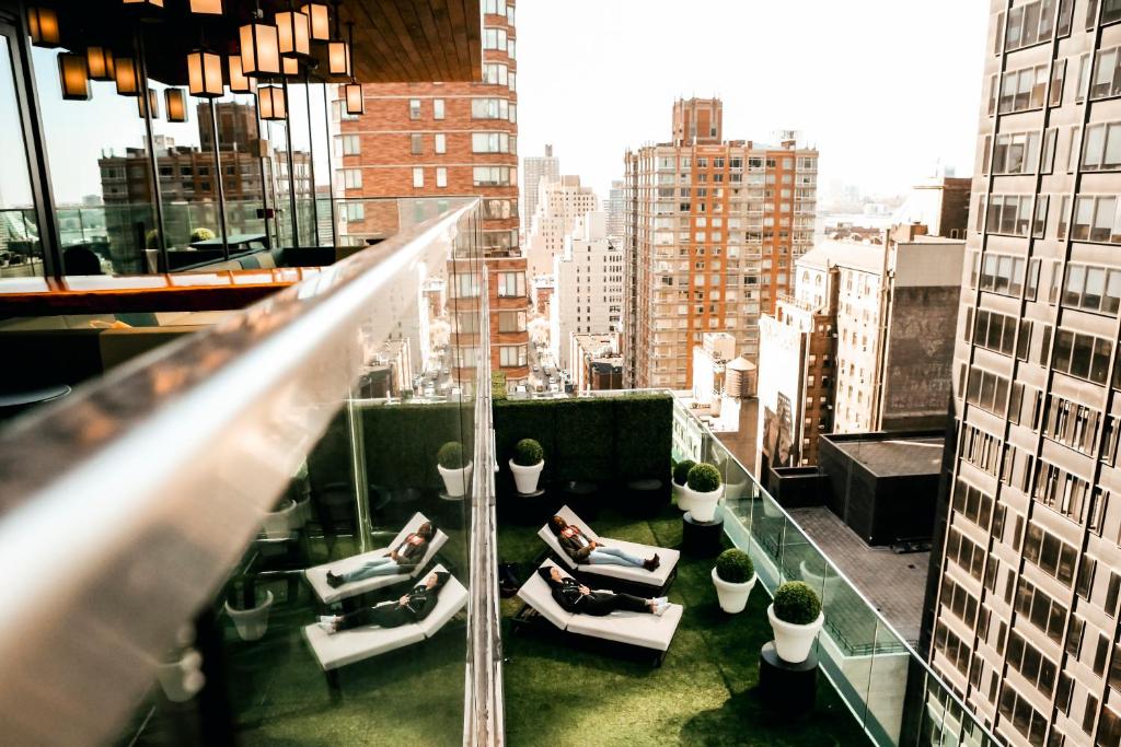 纽约纽约时代广场世民酒店的一座建筑物的阳台,里面的人坐在椅子上