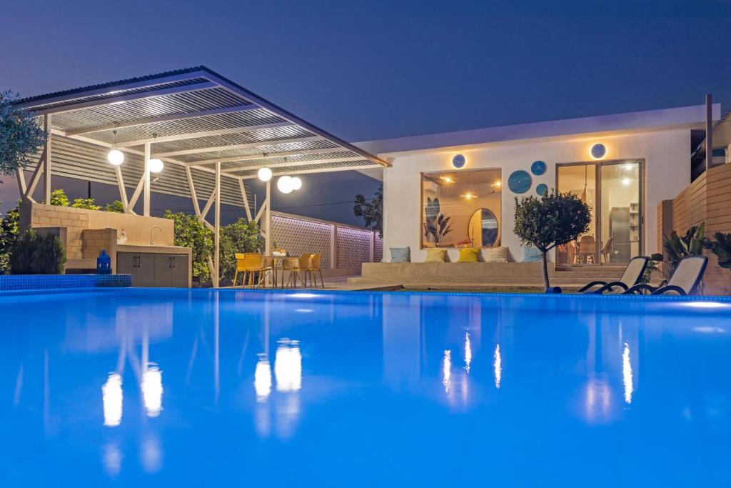 科林比亚Gaia Blue Villa的夜间在房子前面的游泳池