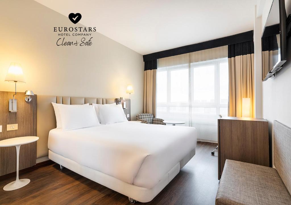 拉科鲁尼亚Eurostars Atlántico的酒店客房设有一张白色大床和一个窗户。