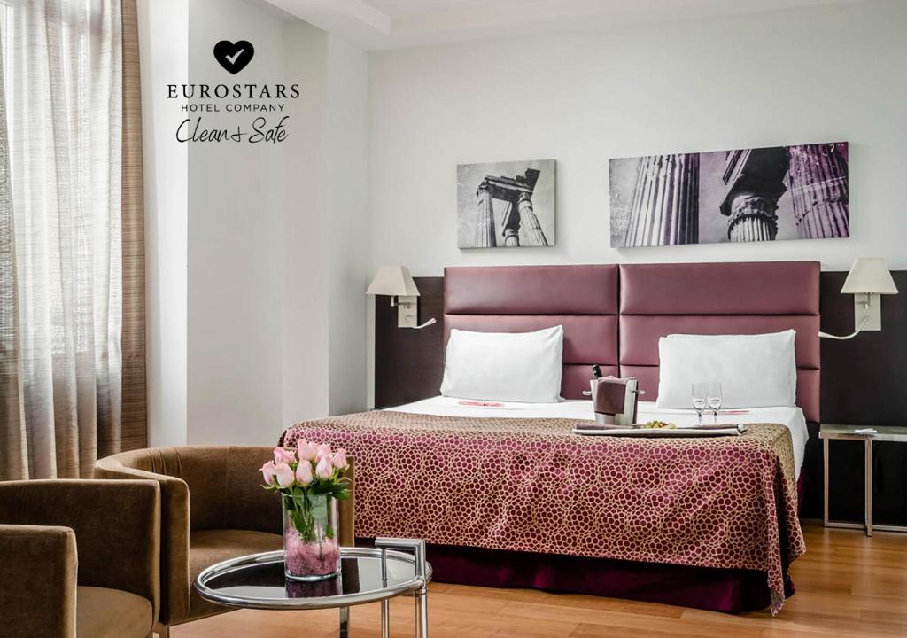 罗马欧洲之星罗马亚特尔纳酒店的一间卧室配有一张床、一把椅子和一张桌子