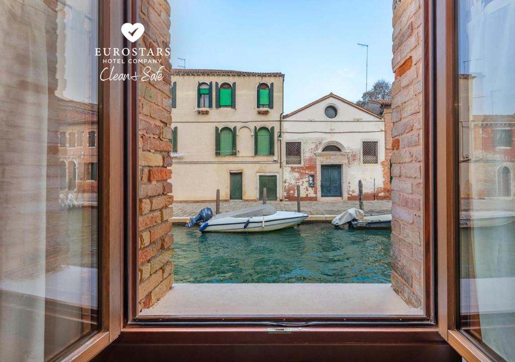 威尼斯欧洲之星卡纳勒酒店的享有运河美景的窗户,设有船只