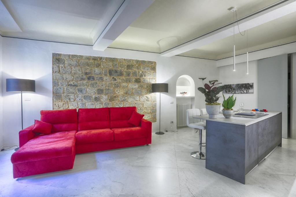 锡耶纳Dimora storica - Palazzo del Taja的客厅配有红色的沙发和桌子