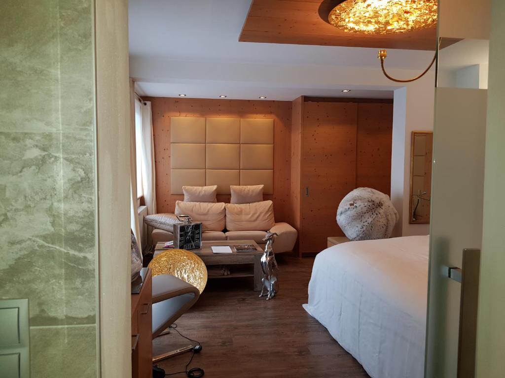 蒂罗尔-泽费尔德韦盖纳酒店的酒店客房,配有床和沙发