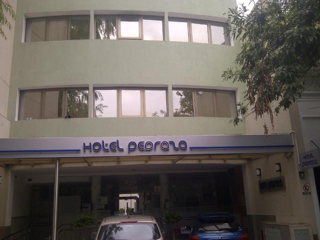 布宜诺斯艾利斯佩德拉萨酒店的酒店前方设有停车场的Pepco大楼