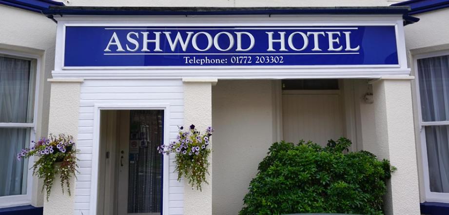 普雷斯顿阿什伍德酒店的建筑前方的一块木头酒店标志