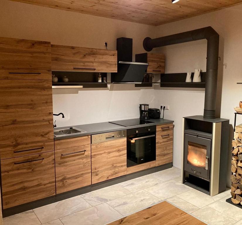 奥西亚歇尔湖畔施泰因多夫Zirben Appartement zwischen Berg und See的厨房配有木制橱柜和炉灶。