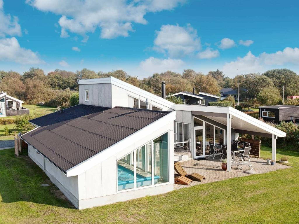 埃贝尔托夫特10 person holiday home in Ebeltoft的白色的房子,设有游泳池和屋顶