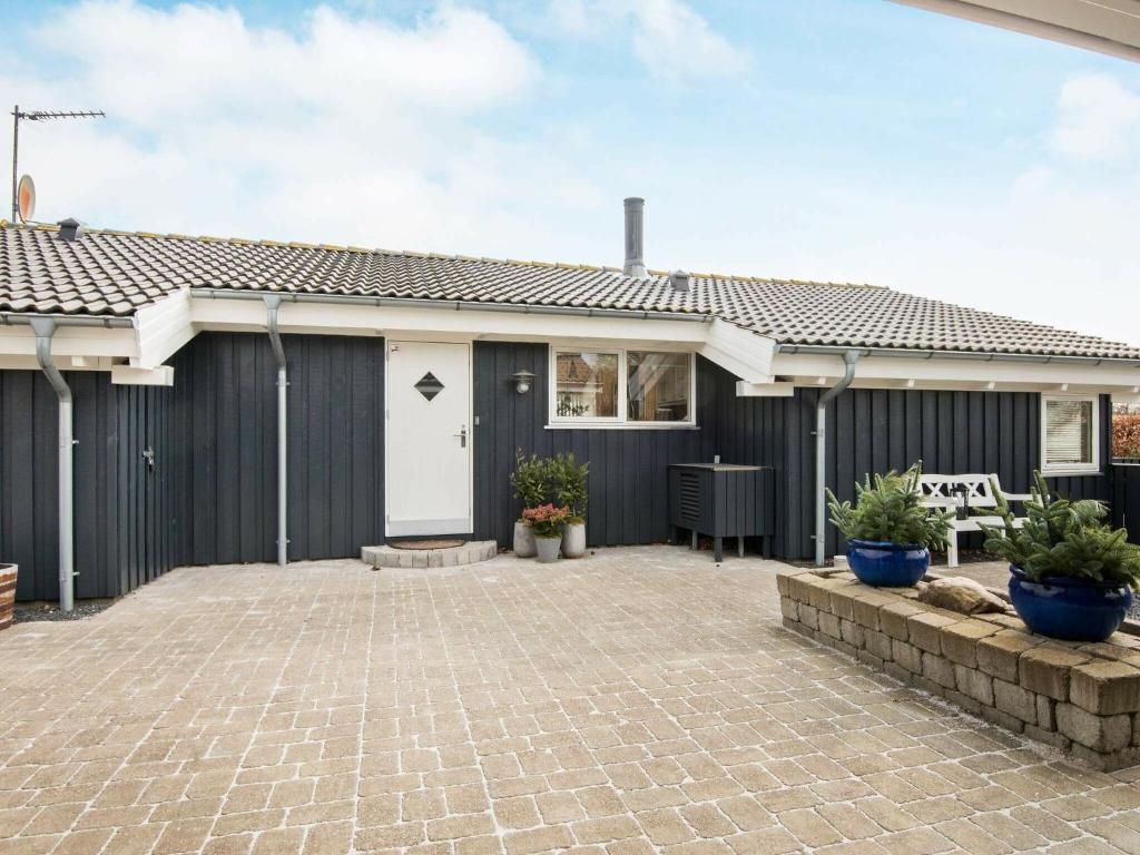 埃贝尔托夫特6 person holiday home in Ebeltoft的一座带黑色围栏和庭院的房子