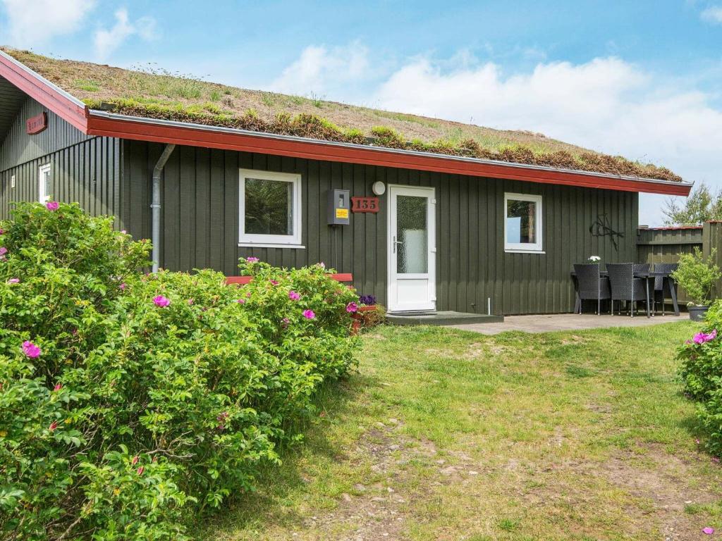 博利尔马克6 person holiday home in R m的一座带草屋顶的绿色小房子
