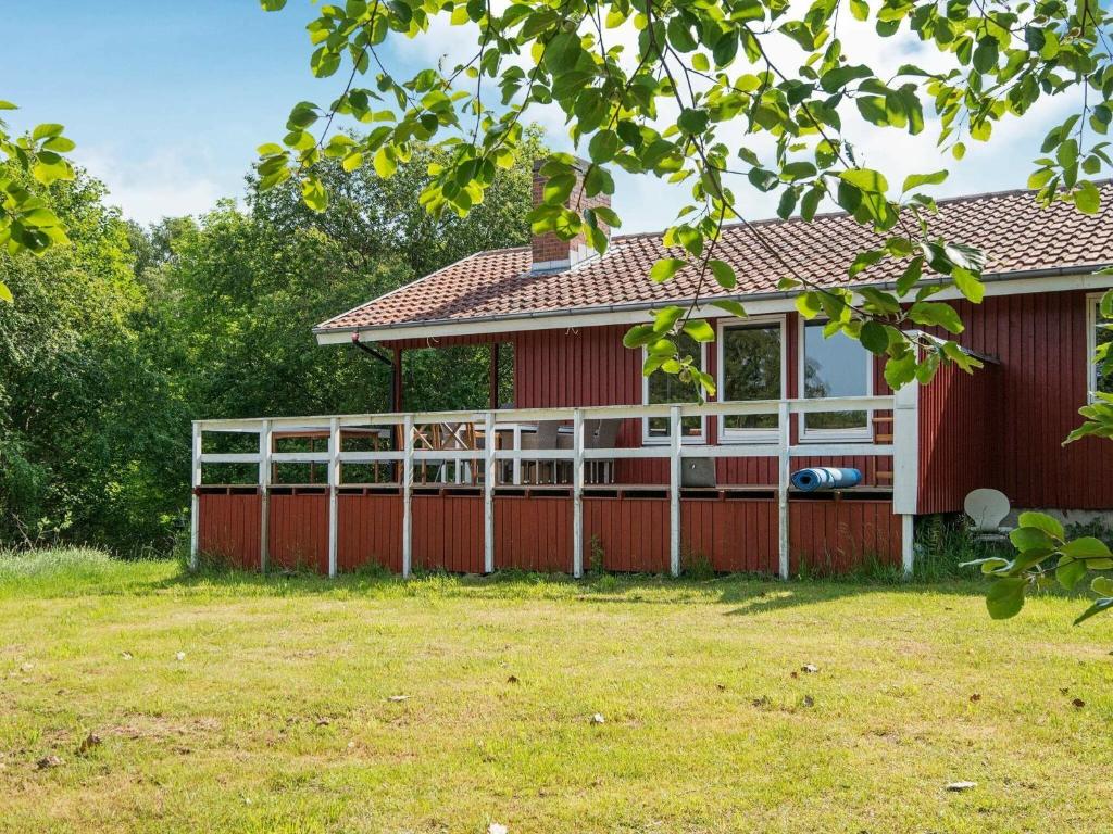 格莱斯堡6 person holiday home in Glesborg的院子里有白色围栏的红色房子