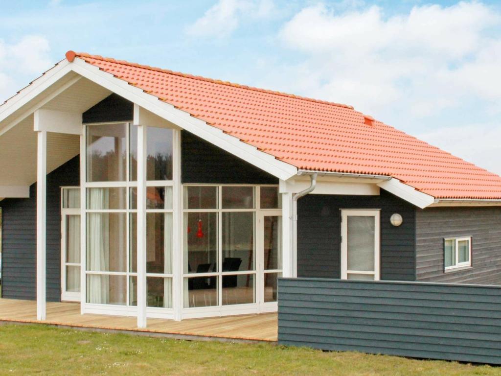 法贾德嘉德8 person holiday home in Ulfborg的一座带橙色屋顶的房屋