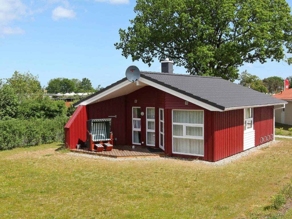 格洛米茨6 person holiday home in GROEMITZ的院子里有甲板的红色棚子