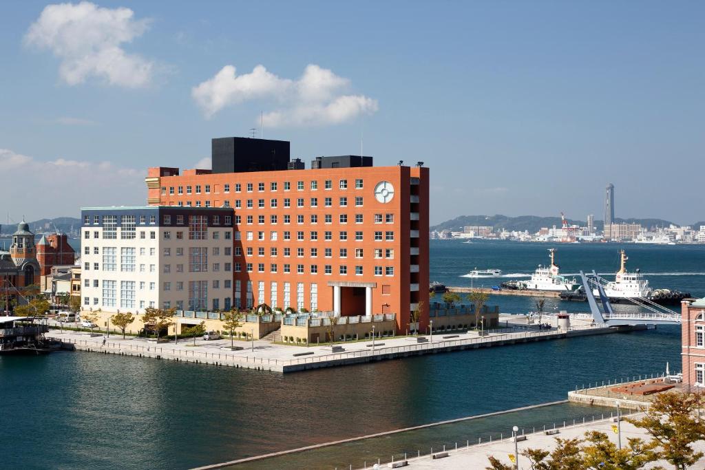 北九州门司港普乐美雅酒店的一座大型砖砌建筑,在水边有一个钟