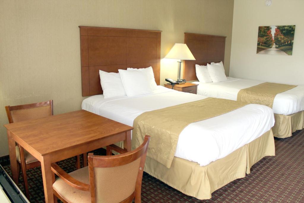 富兰克林富兰克林贝蒙特旅馆套房酒店的酒店客房设有两张床、一张桌子和一张书桌。