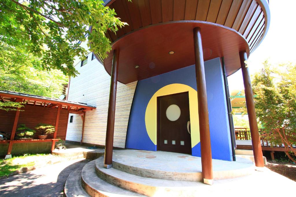 南阿苏村Tsukitei的一座蓝色和黄色建筑的小房子