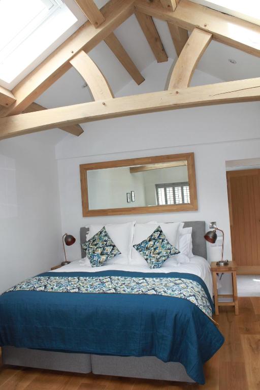 PaulBryher Cottage的一间卧室配有一张大床和大镜子