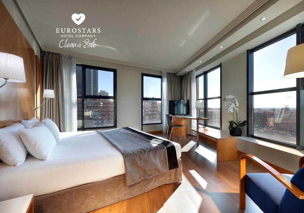 马德里埃克广场酒店的一间卧室设有一张大床和大窗户