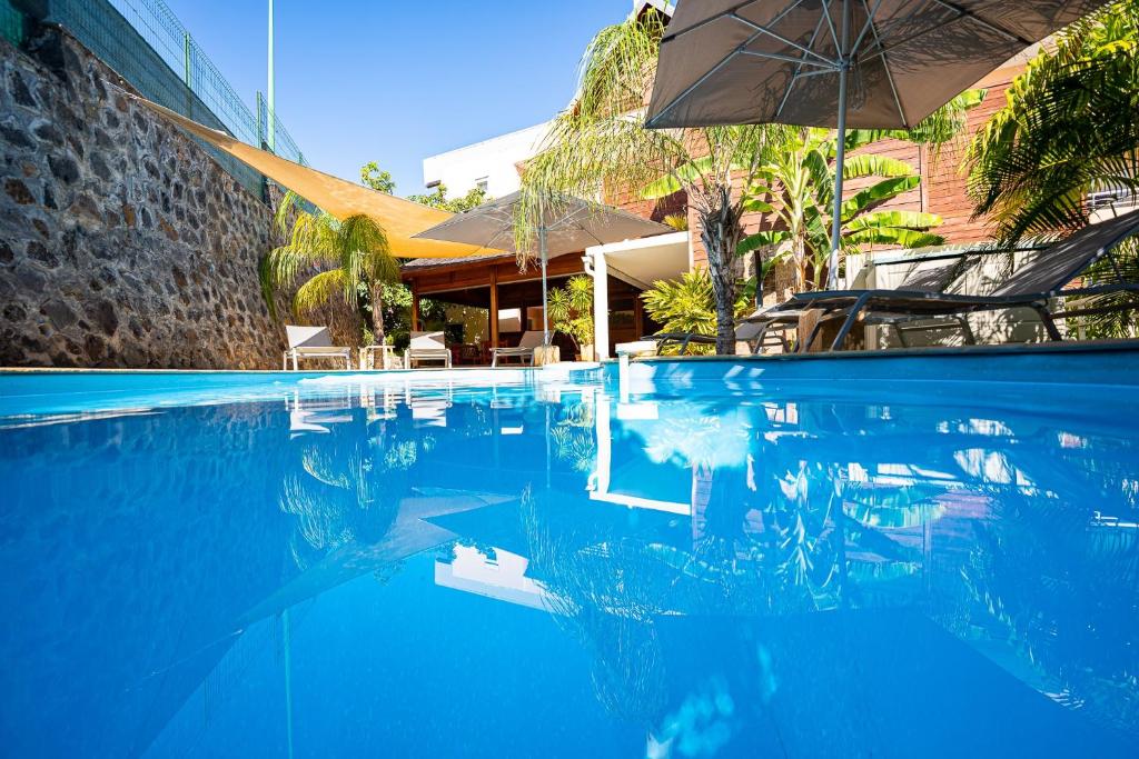 圣吉尔莱班克尔维根旅馆的一个带遮阳伞和椅子的游泳池