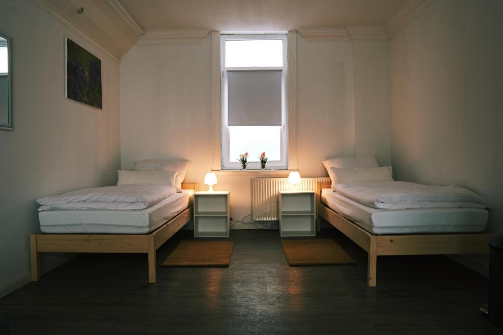 不莱梅Pension & Monteurwohnungen Burglesum Bremen的两张床位于带窗户的房间内