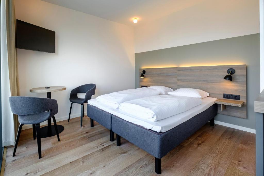 哥本哈根Go Hotel City Apartments的卧室配有一张床和一张桌子及椅子
