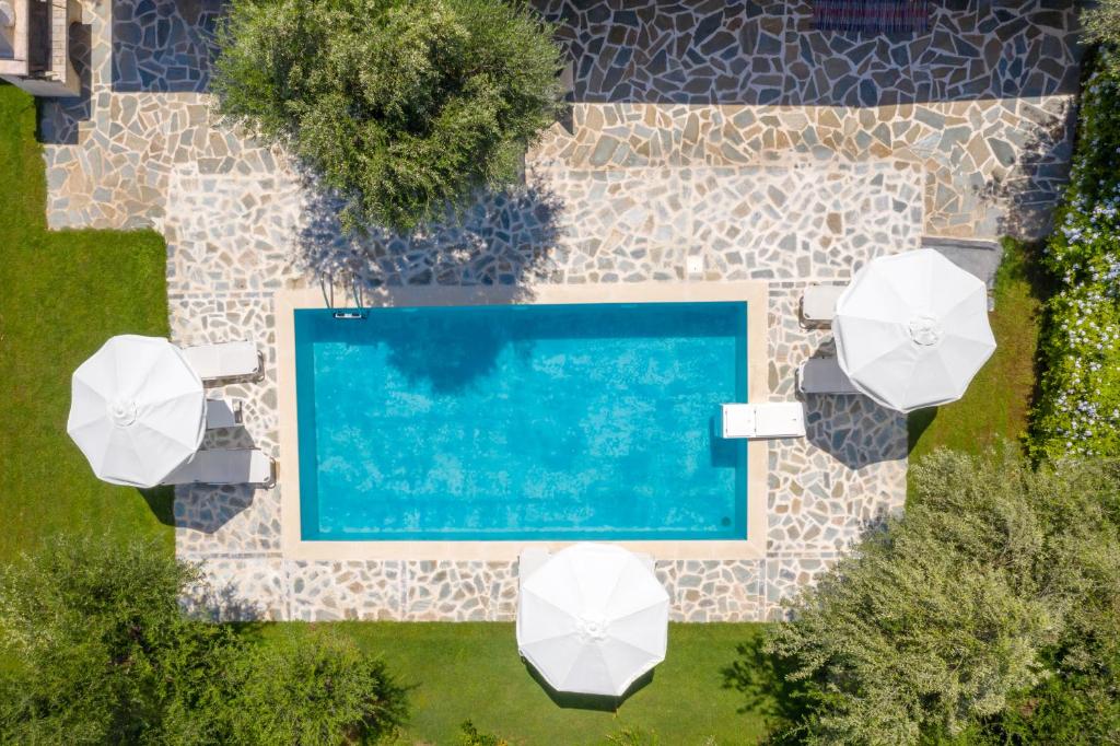 卡拉马孔Michaelo Villa - Affordable Luxury!的享有带白色遮阳伞的游泳池的顶部景致