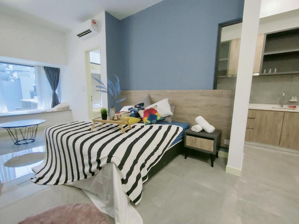 马六甲Imperio Residence Bathtub Studio Melacca Town-FreeParking的一间卧室配有一张黑白条纹的床
