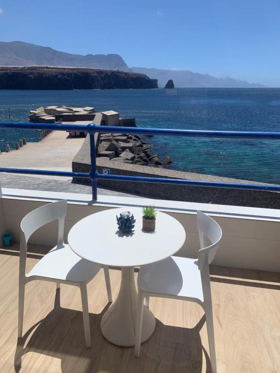 萨迪纳Touch the Sea的阳台上配有白色的桌椅,享有海景