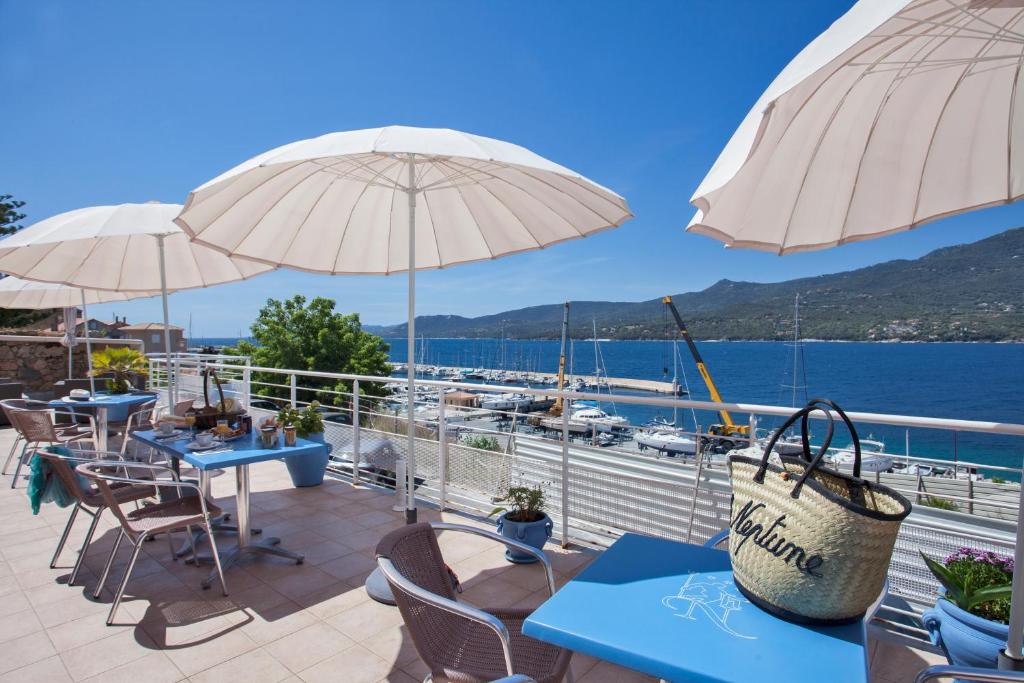 普罗普里亚诺勒纳普图酒店及水疗中心的一个带桌子和遮阳伞的海景露台