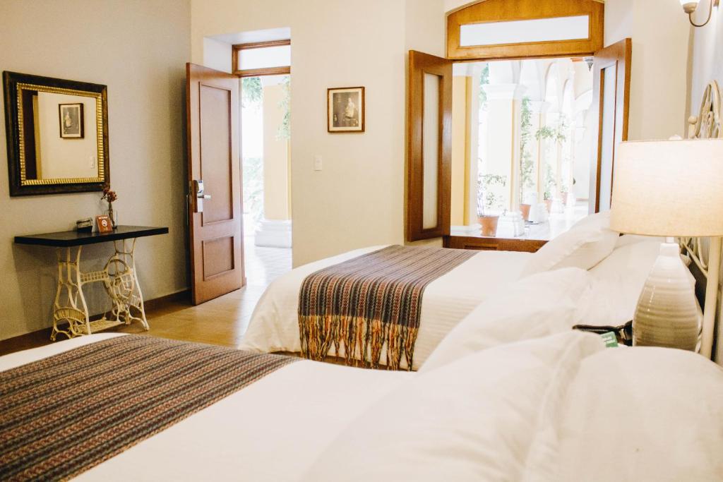 科利马Hotel La Casona de Don Jorge的配有窗户的酒店客房内的两张床
