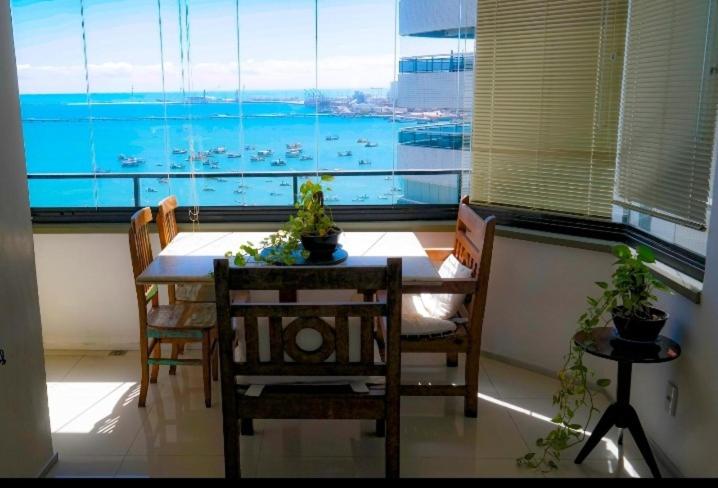 福塔莱萨Flat Beira Mar Golden Fortaleza的一间带桌椅和大窗户的用餐室
