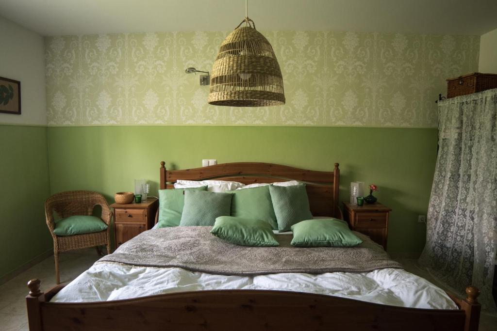 摩拉瓦托普利采Hiša Antonija的一间卧室设有一张带绿色墙壁的床